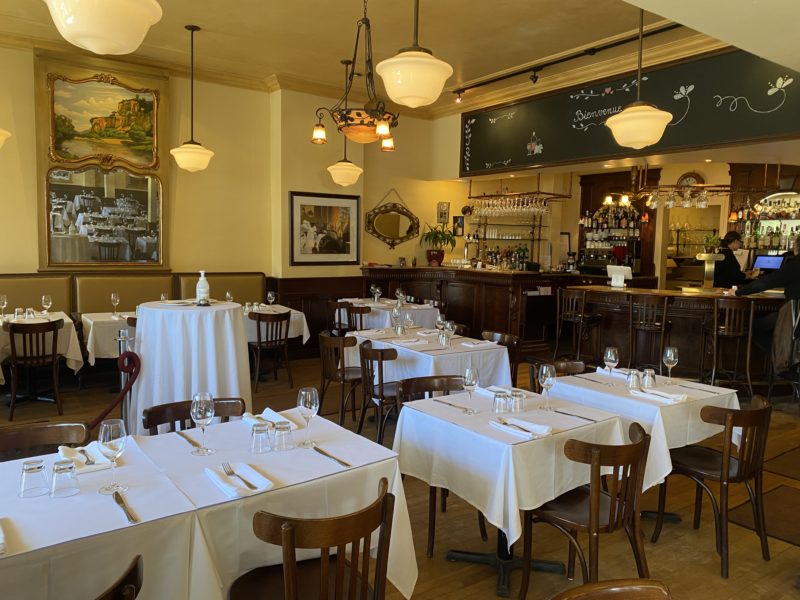 Salle de restaurant art déco Tables avec nappes blanches et joli bar en bois 1900