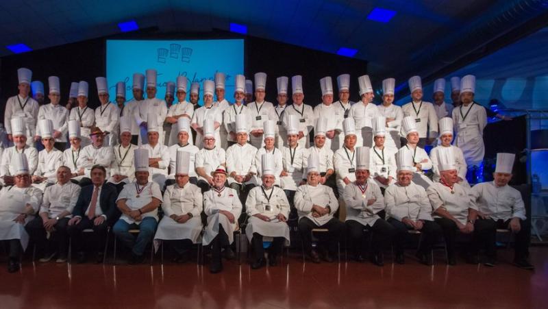 Quarante chef posent sur une photo avec leurs blouses blanches et leurs toques blanches 