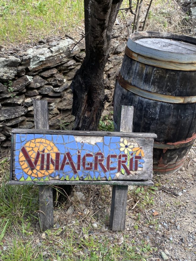 Panneau signalant la vinaigrerie. Il est en carreaux cassés bleus, jaunes, rouges