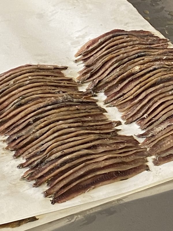 Les anchois sans arrêtes sont posés sur un papier alimentaire 