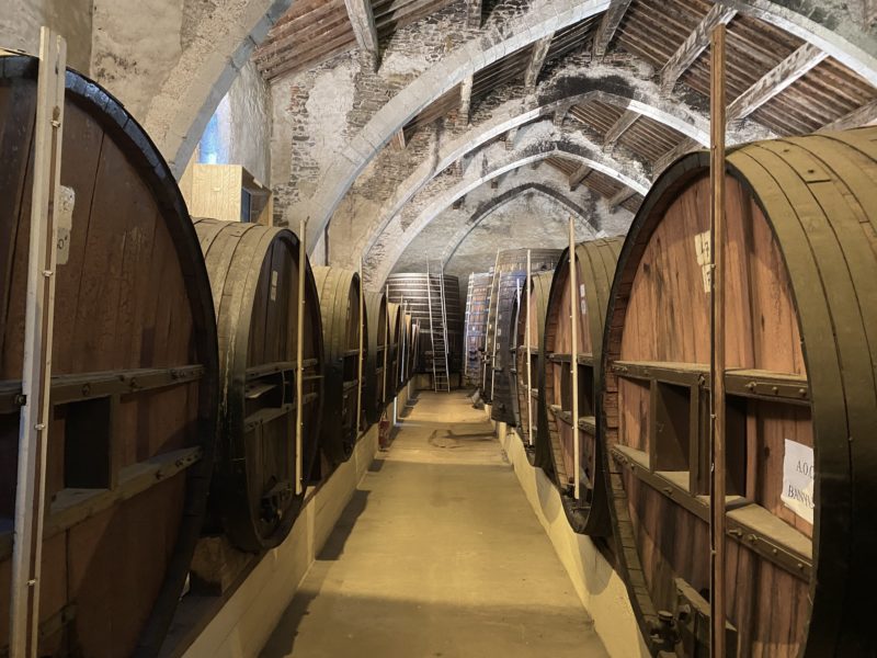Cave à vin installée dans une église avec un alignement de foudres de chênes