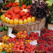 sur le marché corbeilles de fraises, de tomates de courgettes tout est rouge et jaune